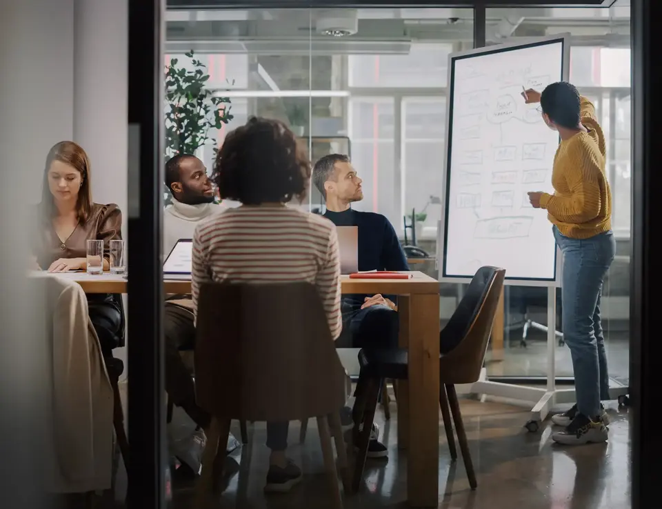a woman standing next to a whiteboard
