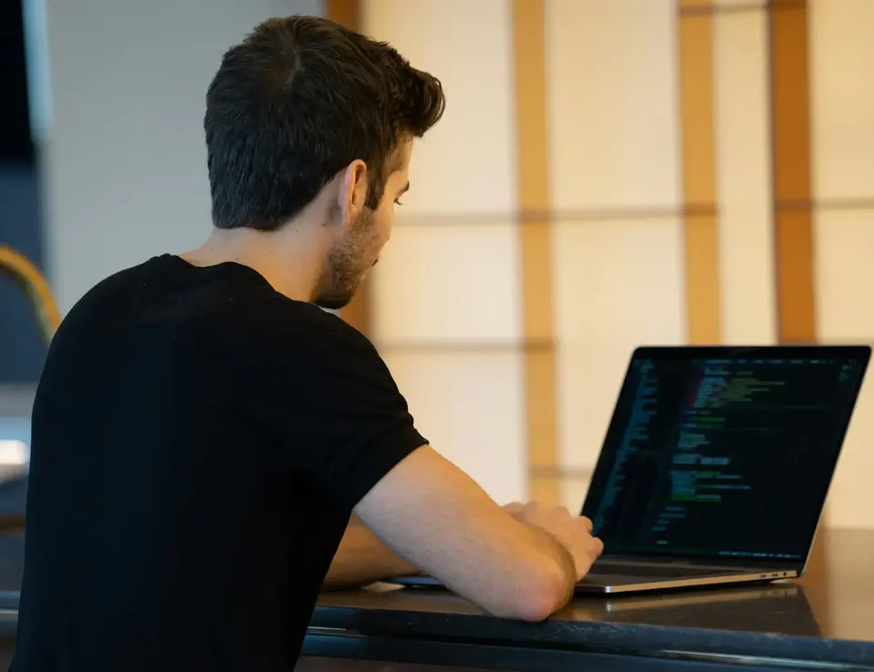 a man sitting at a desk with a laptop