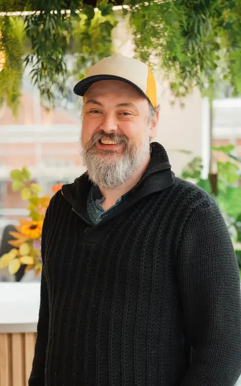a man wearing a black sweater and a yellow hat