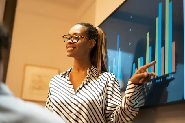 a woman pointing at a screen