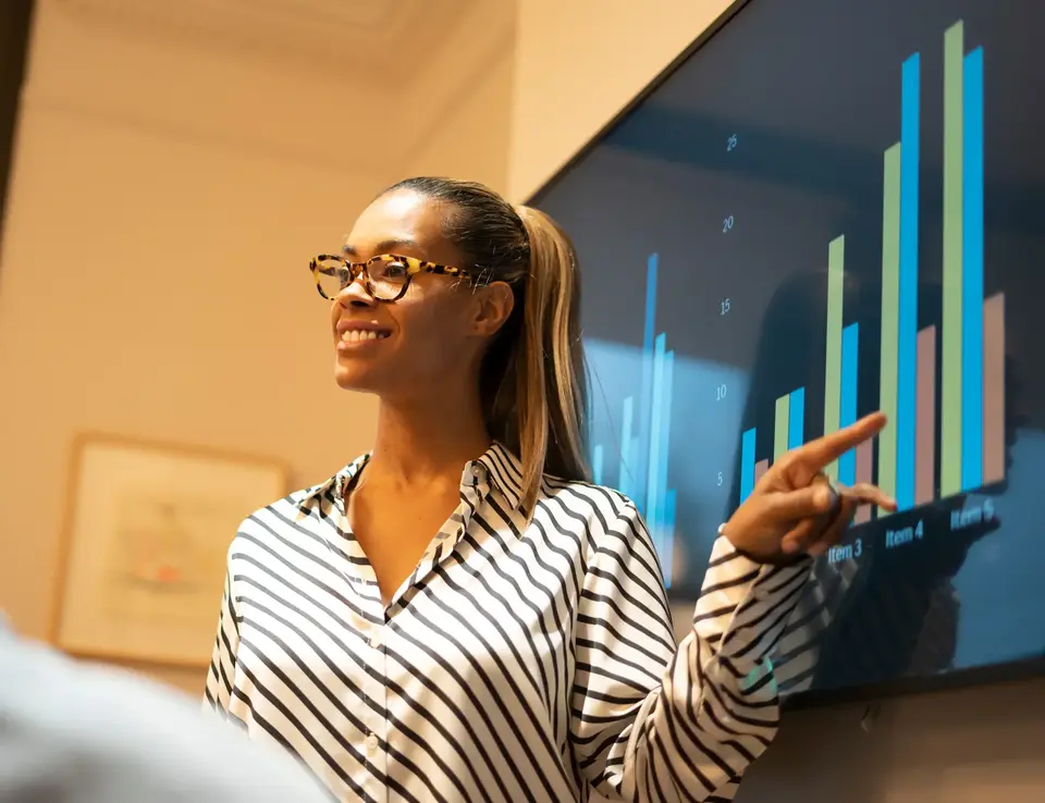 a woman pointing at a screen