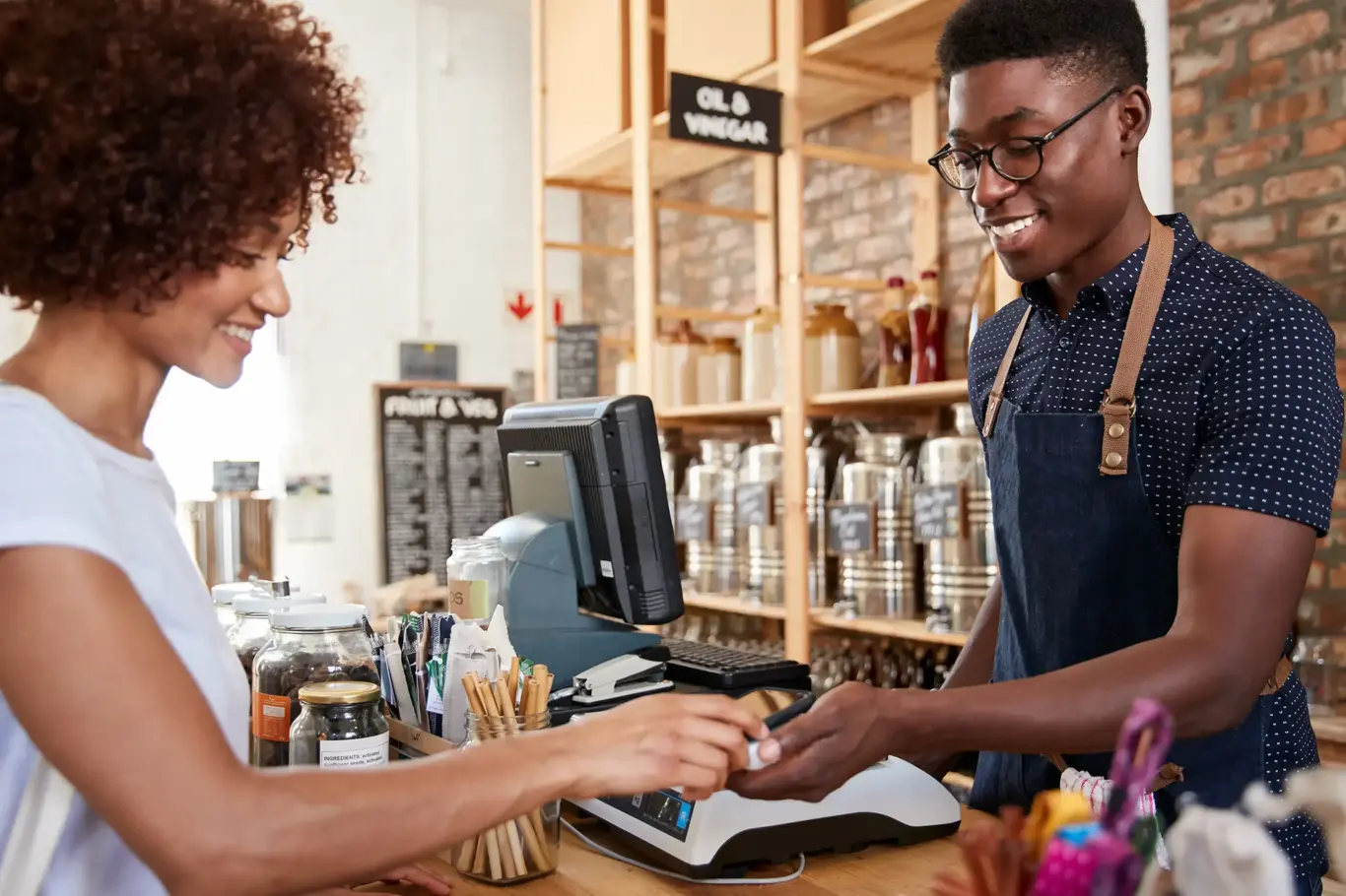 a man and woman paying at a cash register