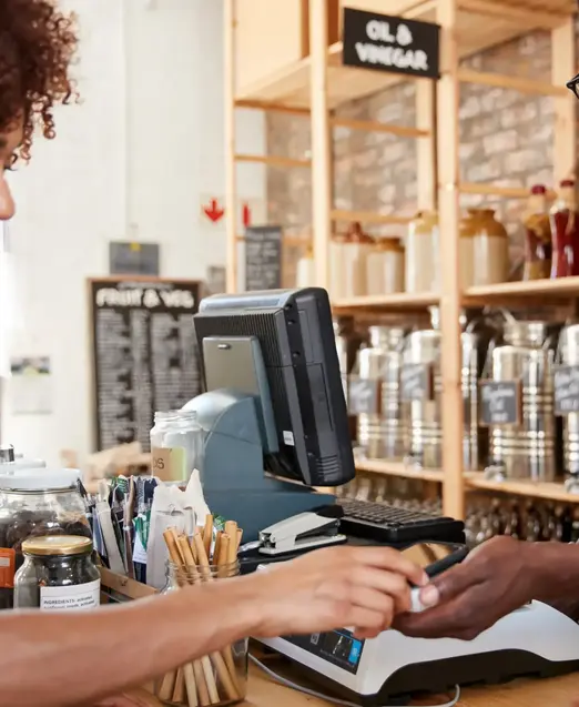 a man and woman paying at a cash register