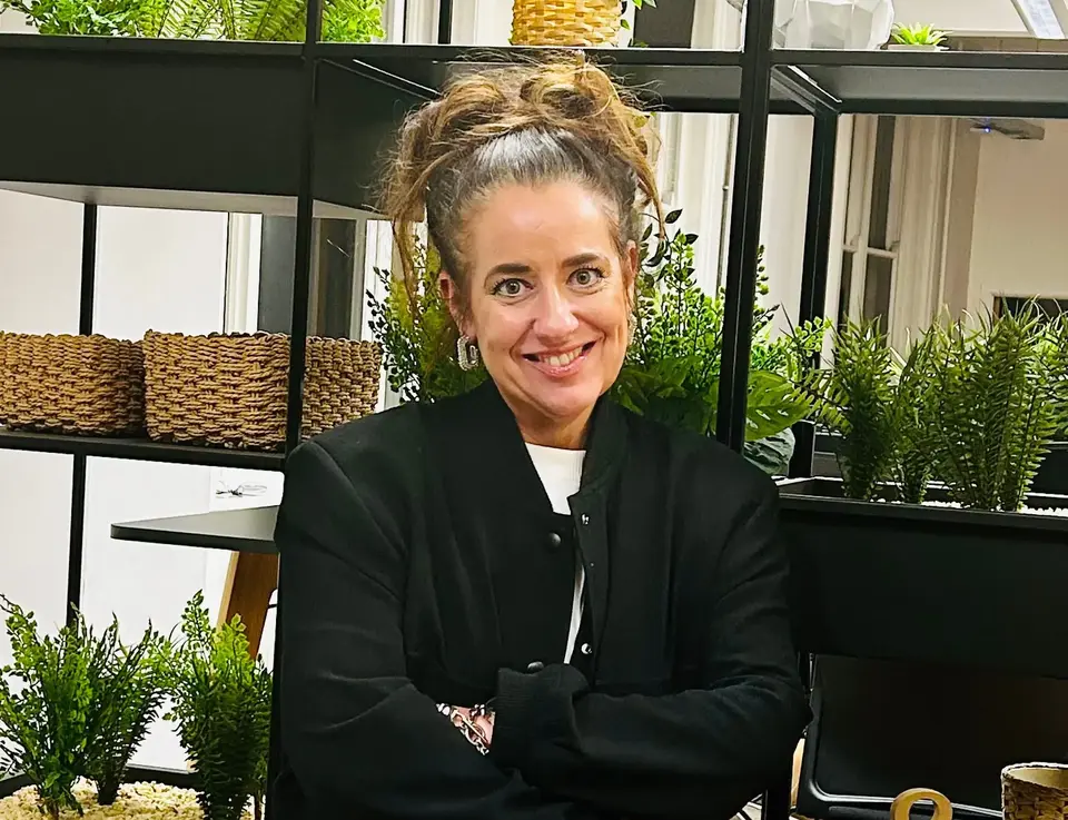 a woman smiling with her arms crossed