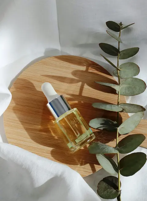 a bottle of oil on a wooden plate