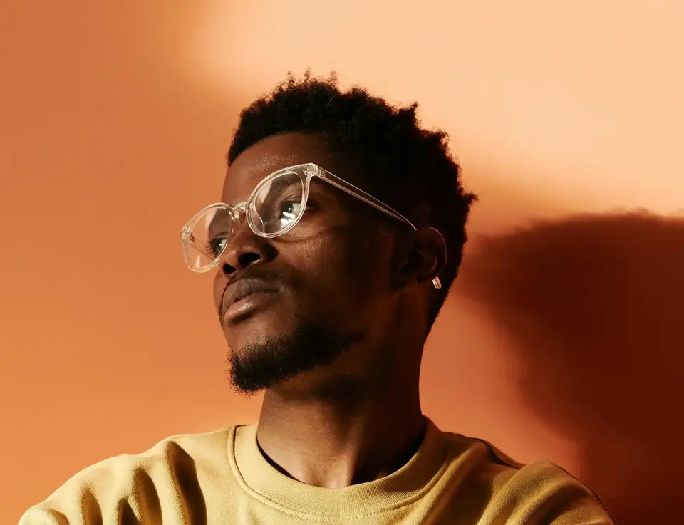 a man wearing glasses and a yellow shirt