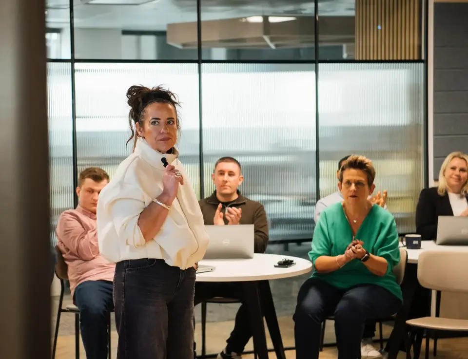 a woman standing in front of a group of people