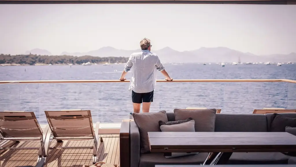 a man standing on a boat looking out to the water