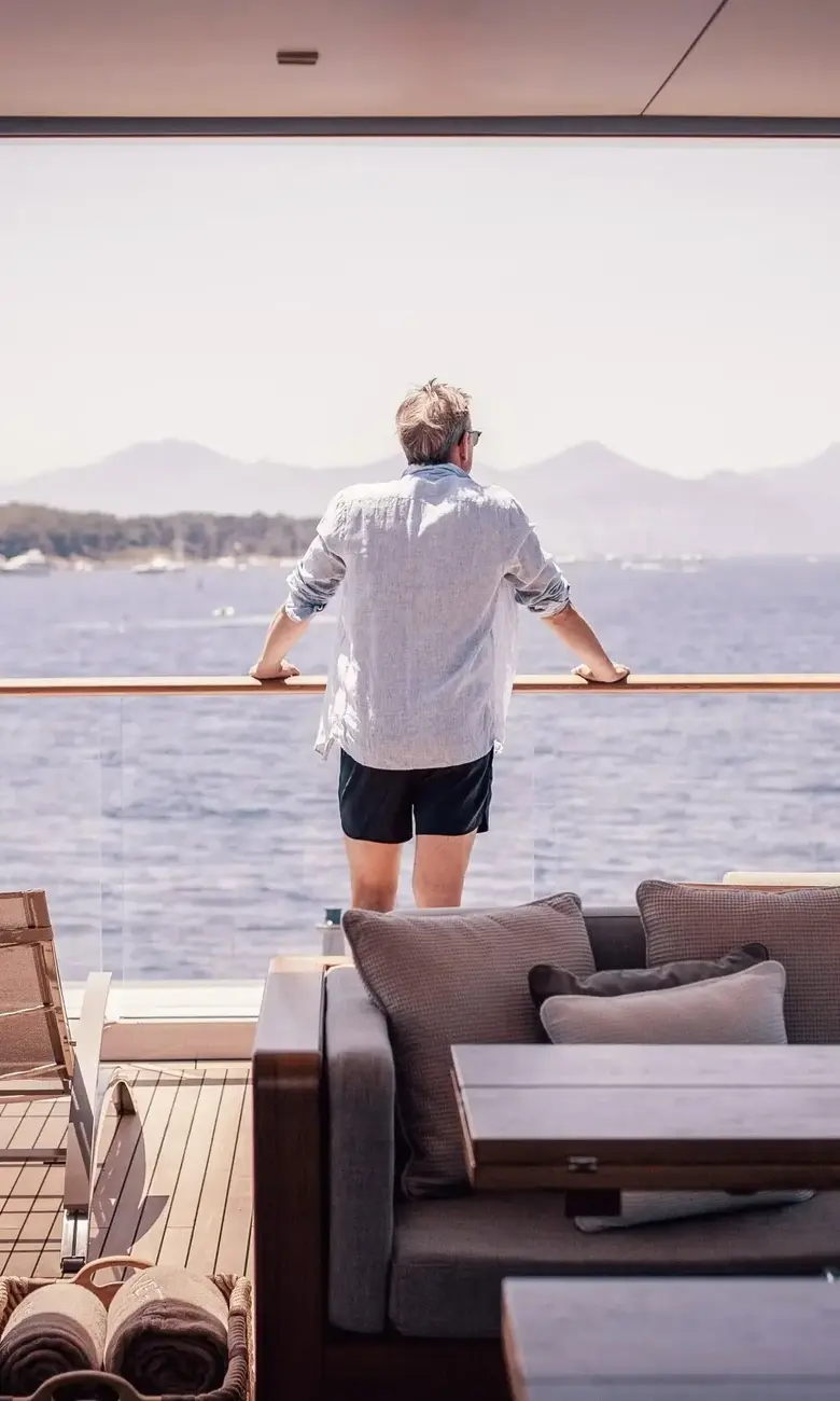 a man standing on a boat looking out to the water