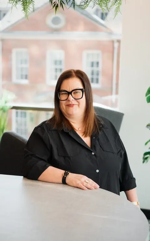 a woman in black shirt and glasses