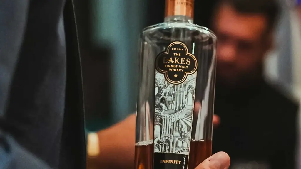 a person holding a bottle of alcohol