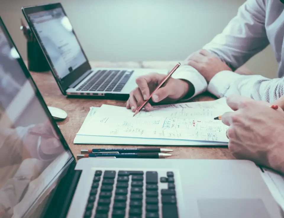 a man holding a pen and writing on a piece of paper