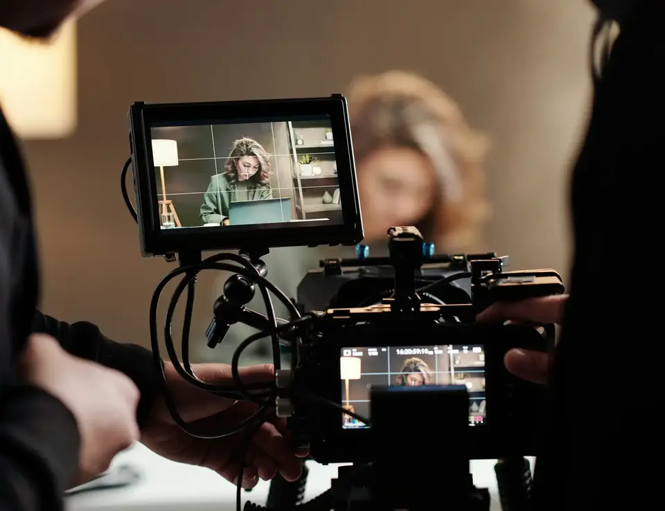 a man holding a camera with a woman in front of it