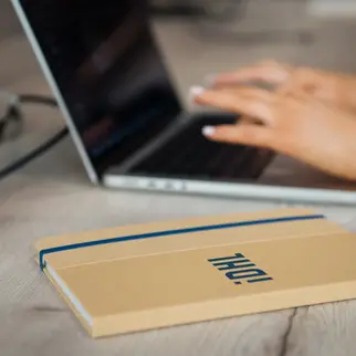 a hand typing on a laptop