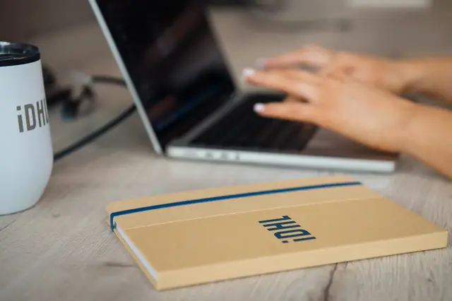 a hand typing on a laptop