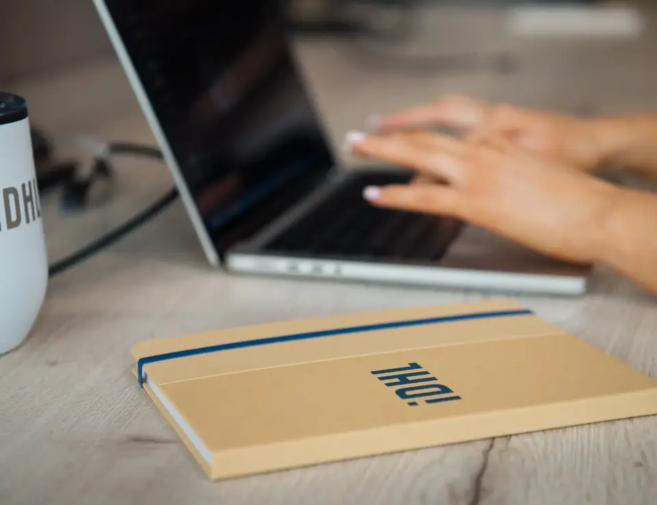a hand typing on a laptop