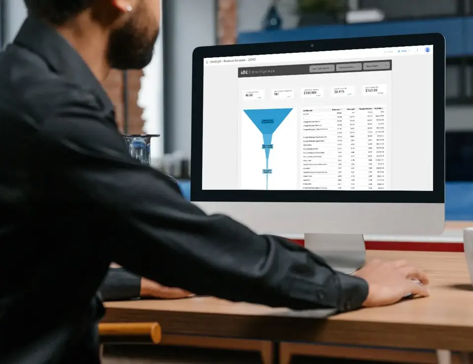 a man sitting at a desk looking at a computer screen