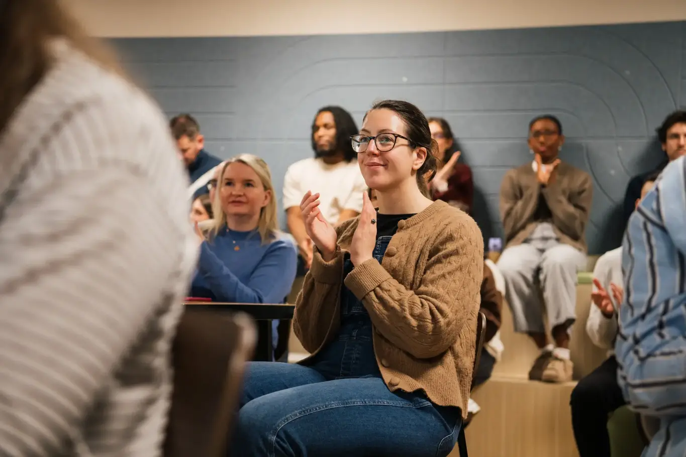 a woman sitting in a chair clapping her hands