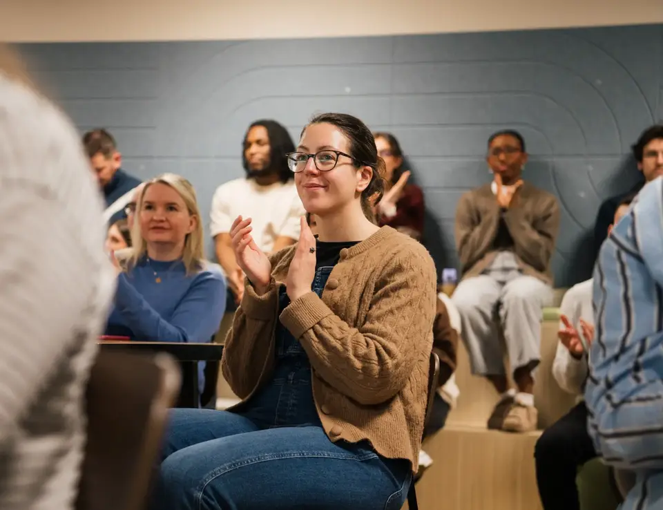a woman sitting in a chair clapping her hands