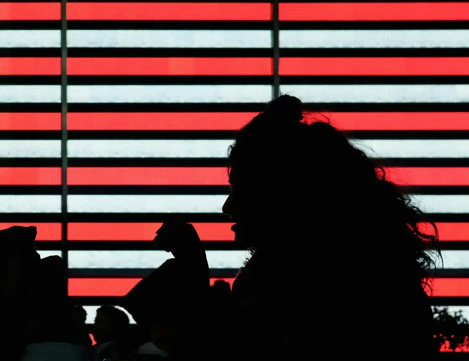 silhouette of people in front of a flag