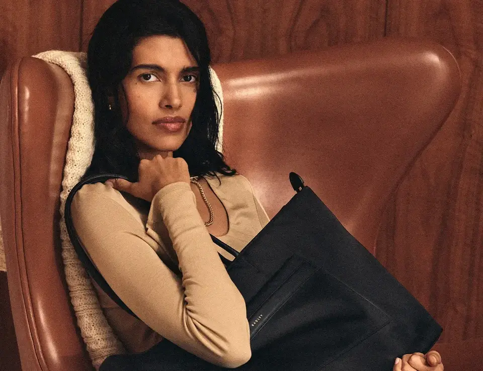 a woman sitting in a chair holding a purse