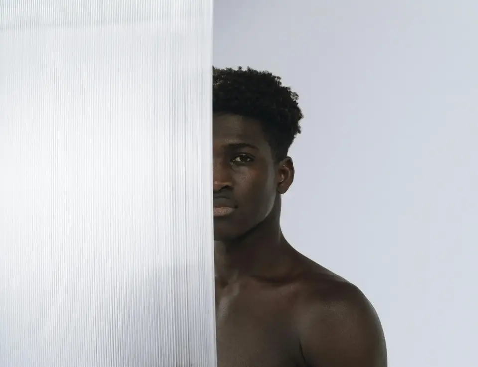 a man standing behind a glass wall