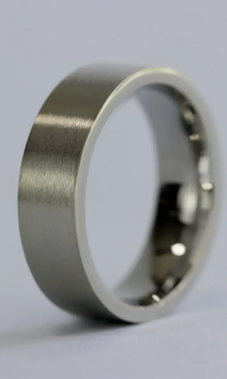 a silver ring on a white surface