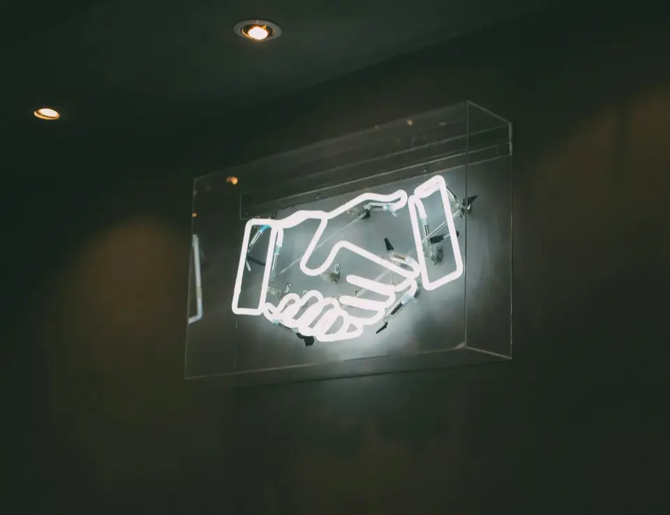 a neon sign with handshake on it