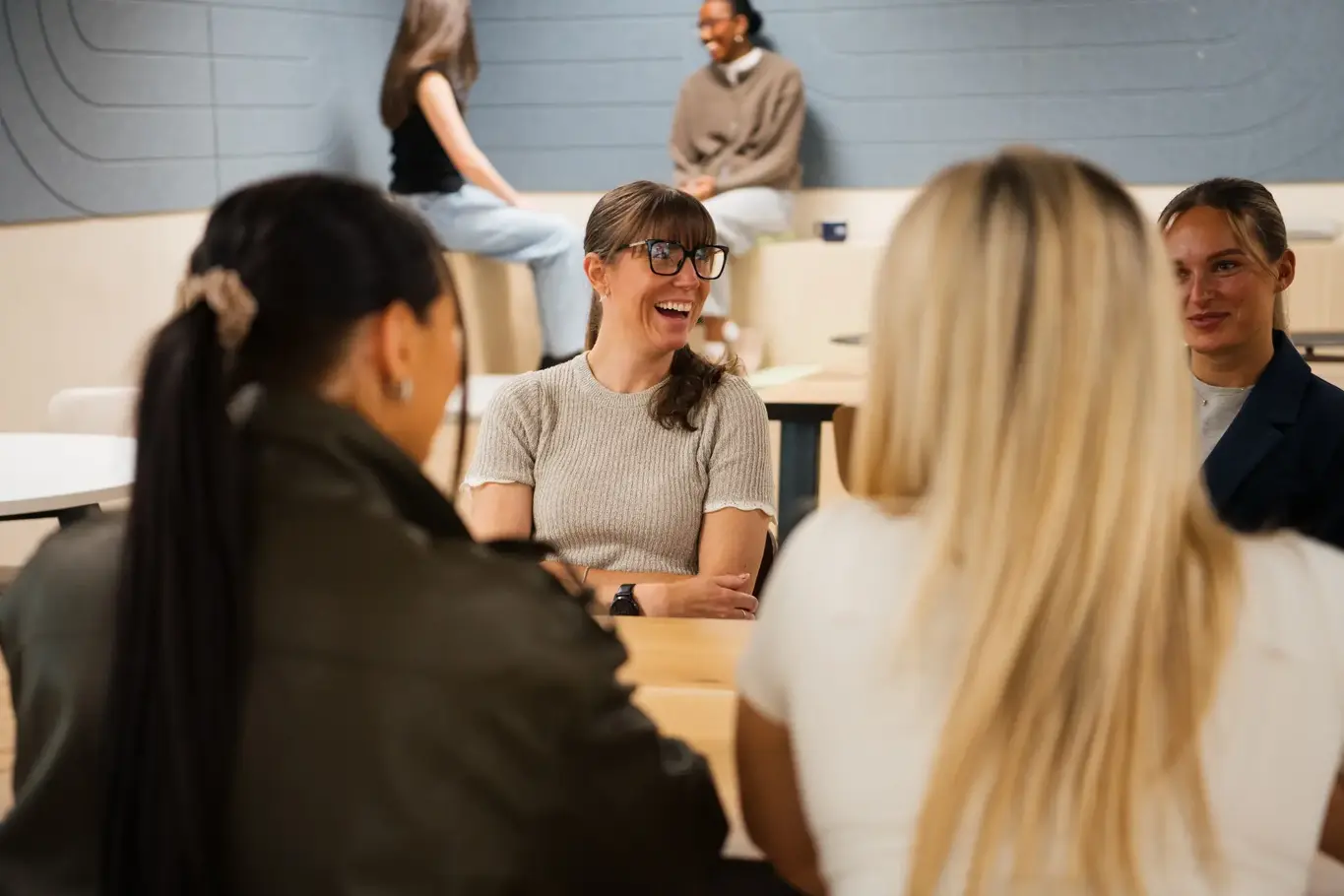 a group of people sitting at tables laughing