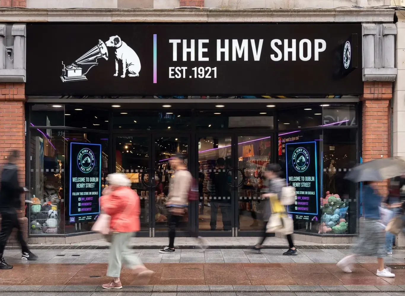 a store front with people walking on the sidewalk