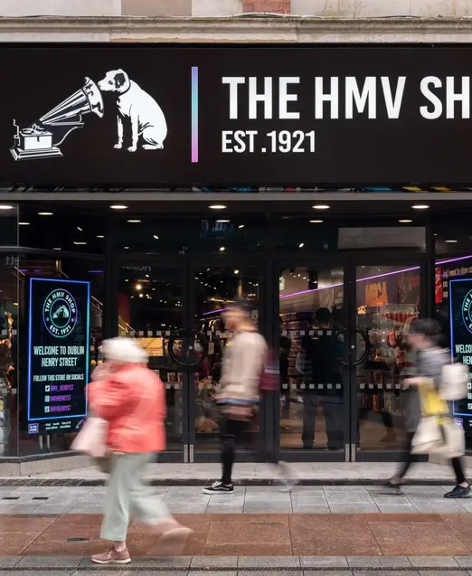 a store front with people walking on the sidewalk