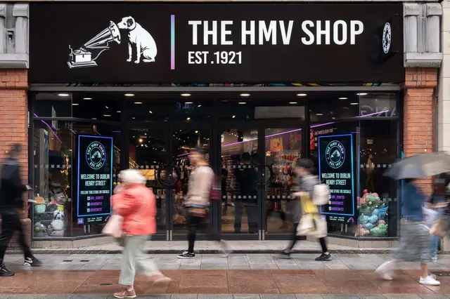 a store front with people walking on the sidewalk