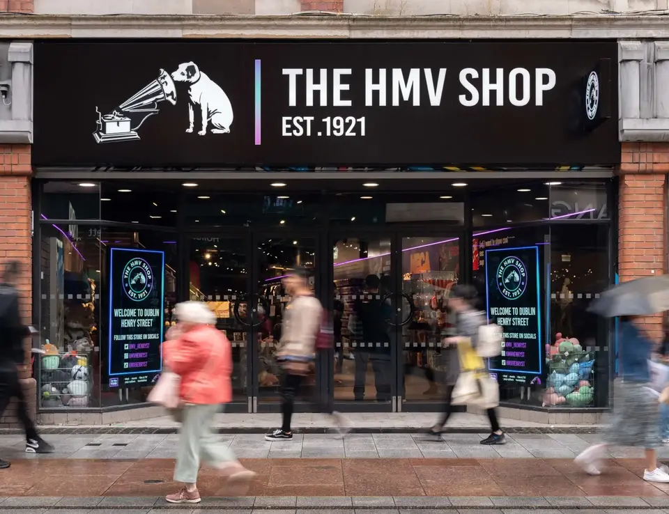 a store front with people walking on the sidewalk