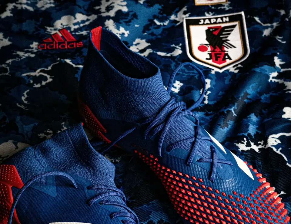 a pair of blue and red football shoes