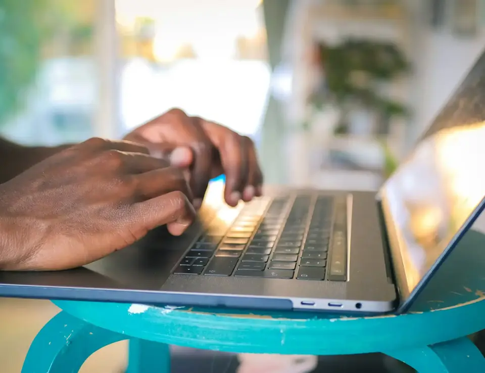 a person's hands on a laptop keyboard
