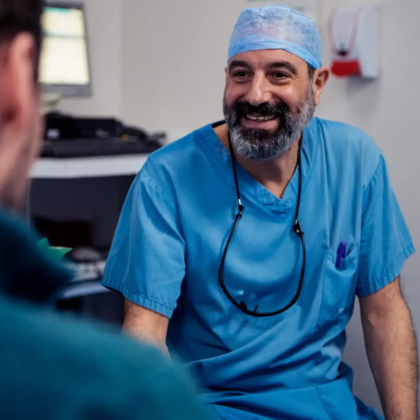 Doctor in blue scrubs sat down smiling