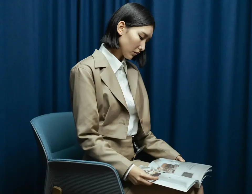 a woman sitting in a chair reading a book