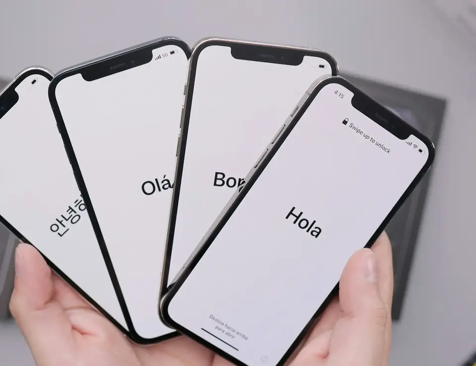 a hand holding several cell phones