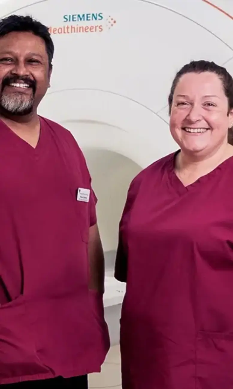 Two clinicians standing in front of an MRI machine