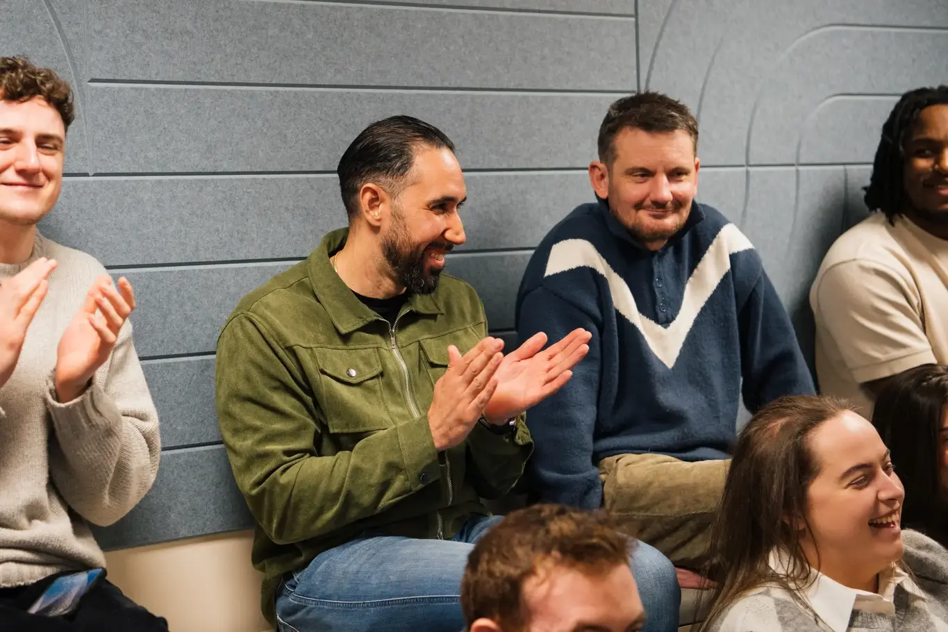 a group of men sitting and clapping