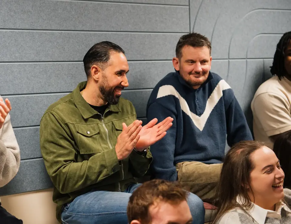 a group of men sitting and clapping