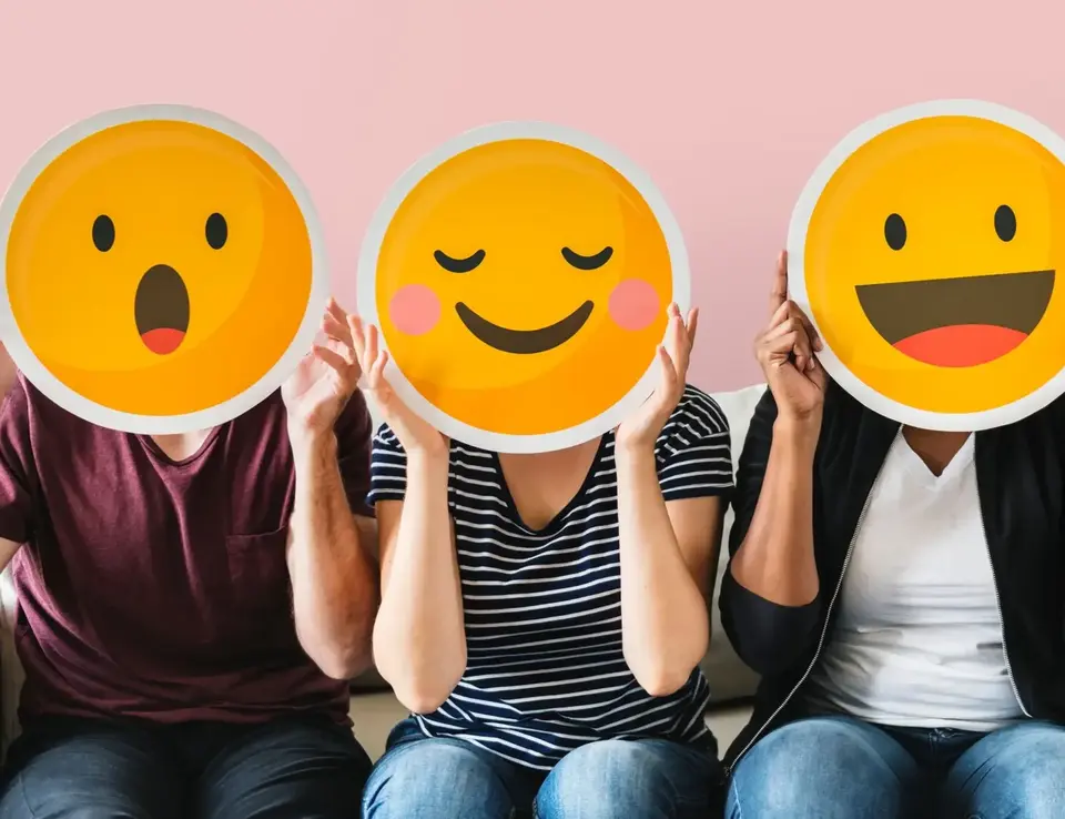 a group of people holding up a yellow emoji