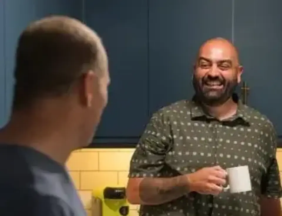 a man holding a cup and smiling