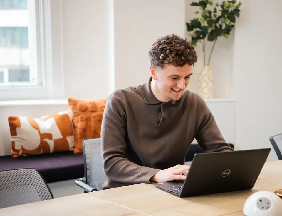 a man sitting at a desk with a laptop