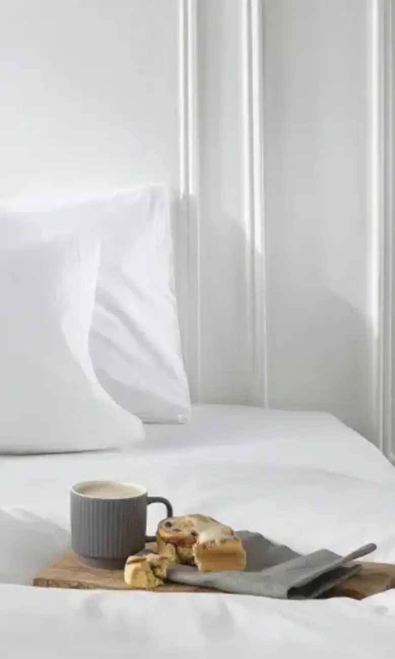 a tray of food on a white duvet set 