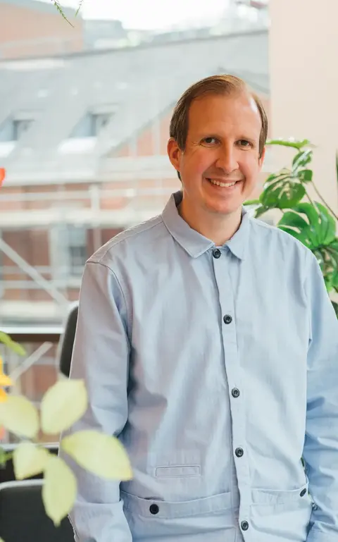 a man standing in front of a plant