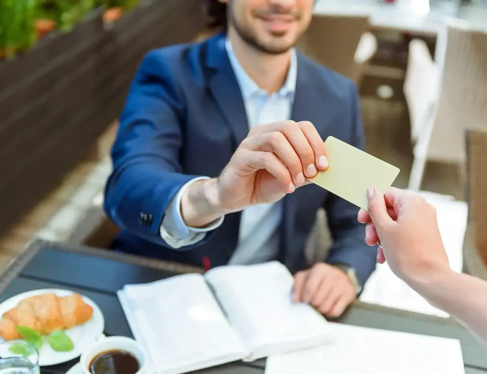a person handing a card to a man