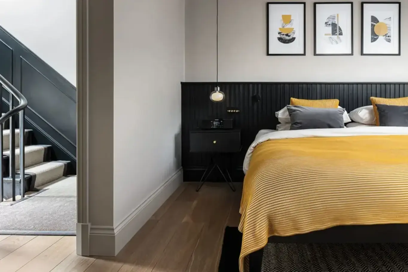 a bed with yellow and grey pillows