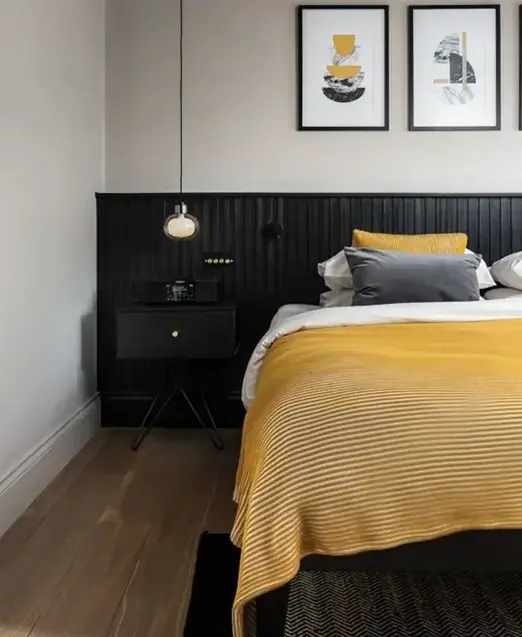 a bed with yellow and grey pillows