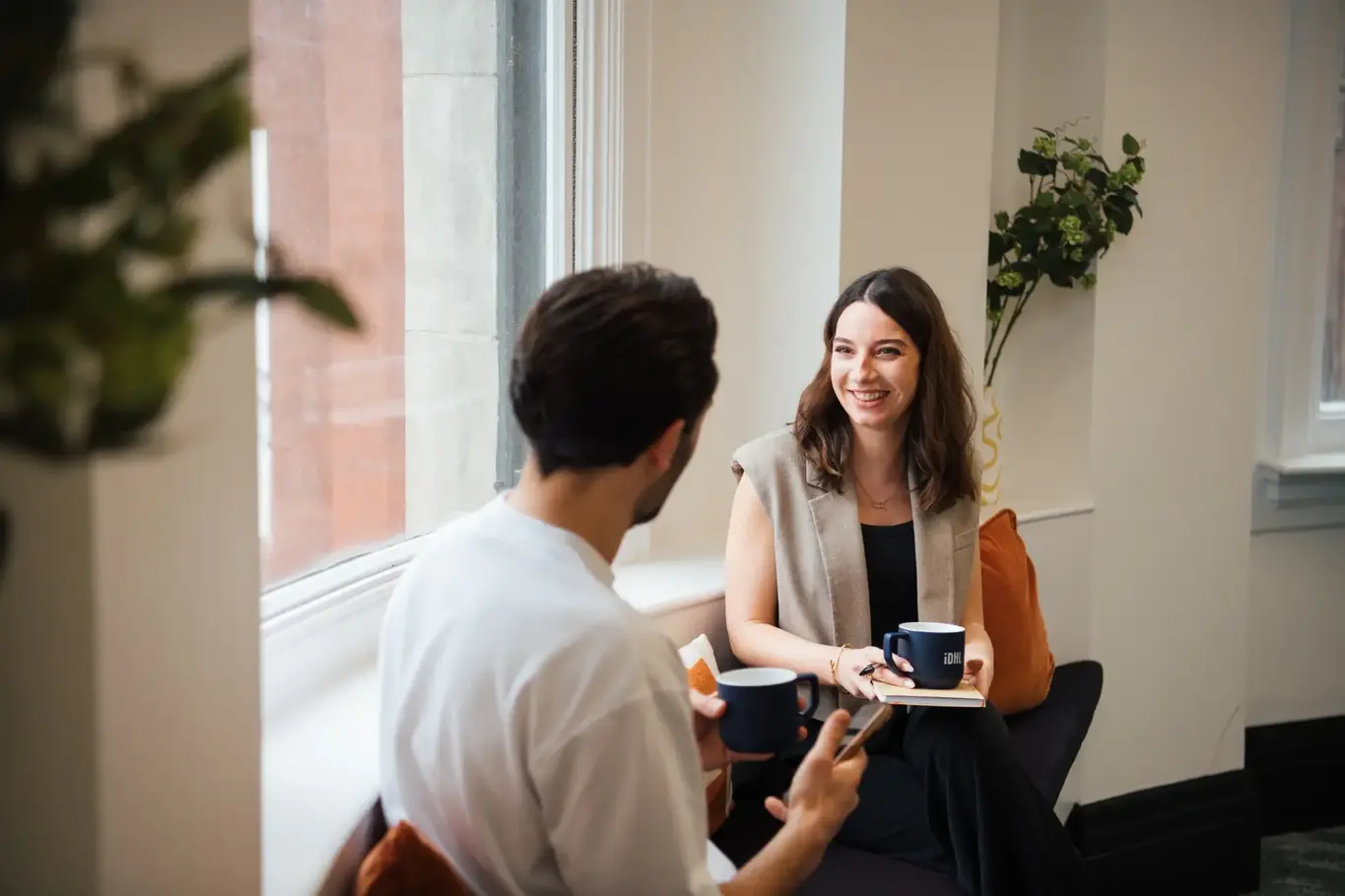 a man and woman sitting in a chair and talking